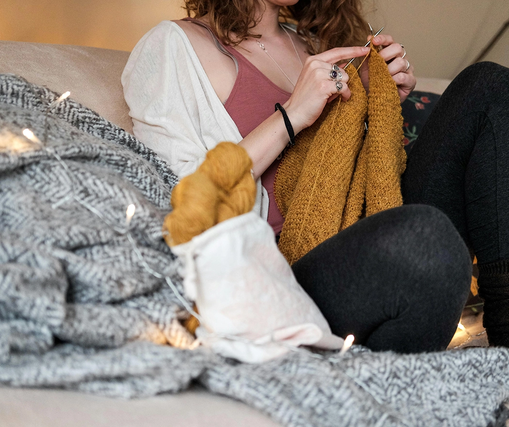 Lady knitting on the sofa